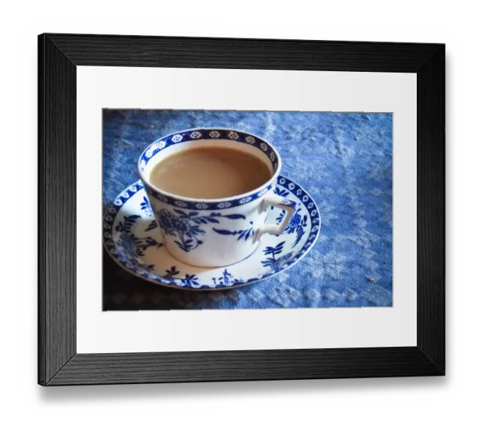 Framed Print : Antique blue and white cup and saucer of Indian tea with milk, on blue tablecloth