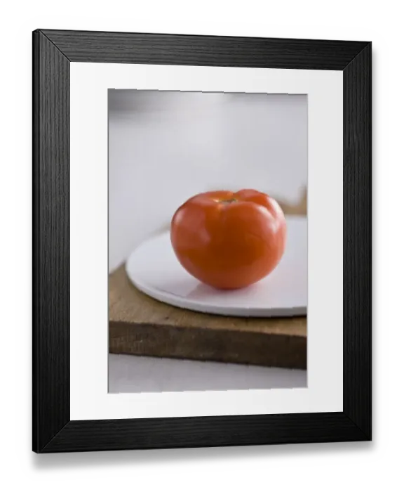 Framed Print : Single red tomato on white platter on wooden board credit: Marie-Louise Avery / Framed Print : Single red tomato on white platter on wooden board credit: Marie-Louise Avery /