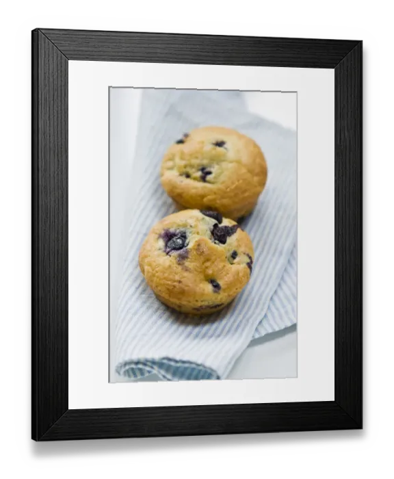 Framed Print : Freshly baked blueberry muffin on blue striped napkin. credit: Marie-Louise Avery