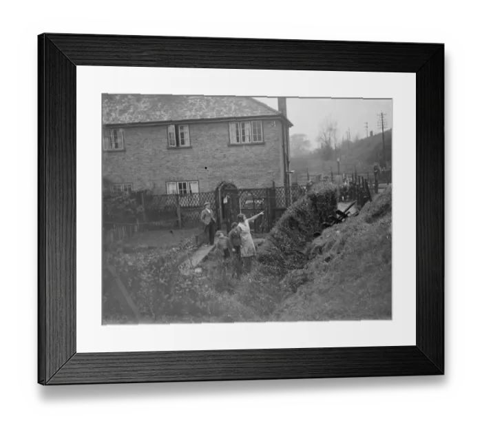 Framed Print : People watch from their back gardens as men work to clear the land slide on the Wellhall
