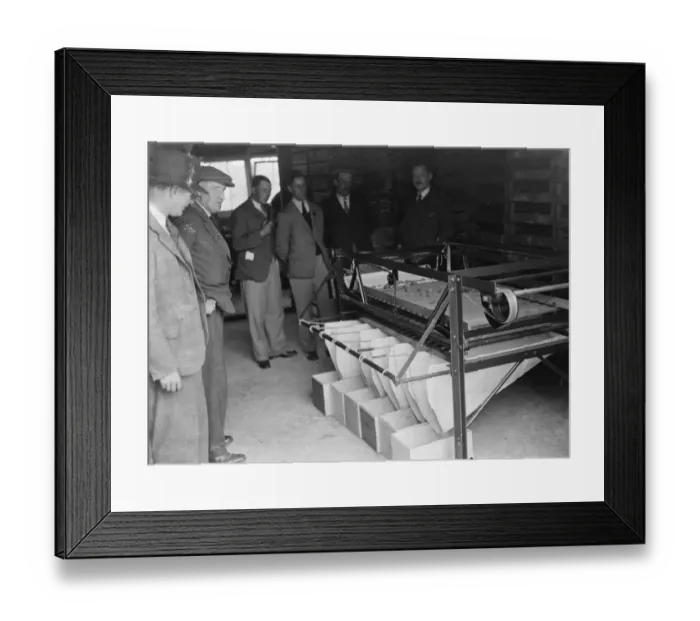 Framed Print : Farmers looking at machinery for fruit grading at the fruit farm. 1935