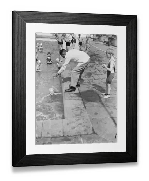 Framed Print : A young girl is taught how to swim with the use of a rope round her waste to keep Framed Print : A young girl is taught how to swim with the use of a rope round her waste to keep