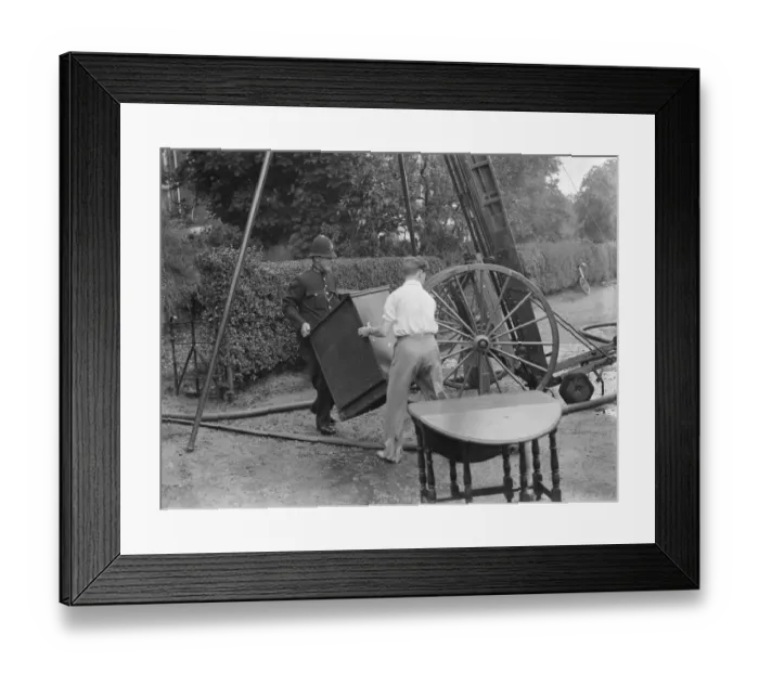 Framed Print : Firemen respond to a house fire in Chislehurst, Kent. A policeman tries to salvage