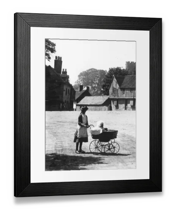 Framed Print : An older sister taking out the baby in a perambulator on a summers day walk taking Framed Print : An older sister taking out the baby in a perambulator on a summers day walk taking