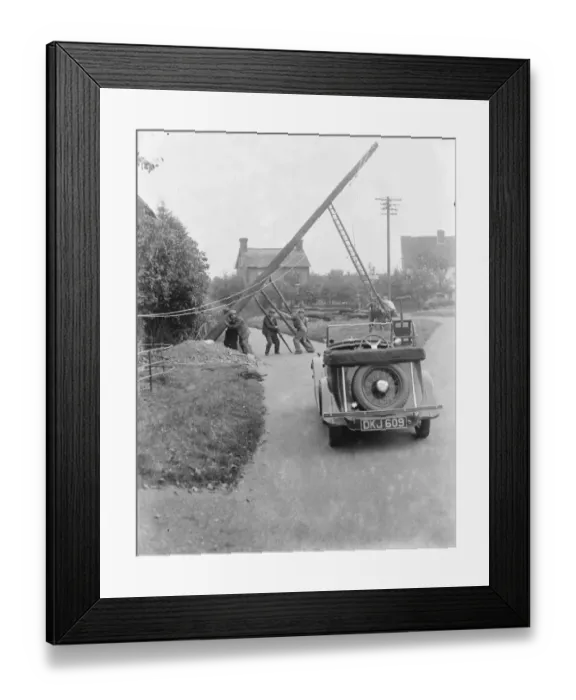 Framed Print : workers use ladders and poles erect an electric pylon next to a road in Trottiscliffe Framed Print : workers use ladders and poles erect an electric pylon next to a road in Trottiscliffe