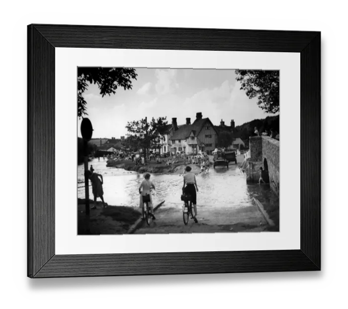 Framed Print : Families play in the flood water in Eynsford Kent. Some of the children paddle others Framed Print : Families play in the flood water in Eynsford Kent. Some of the children paddle others