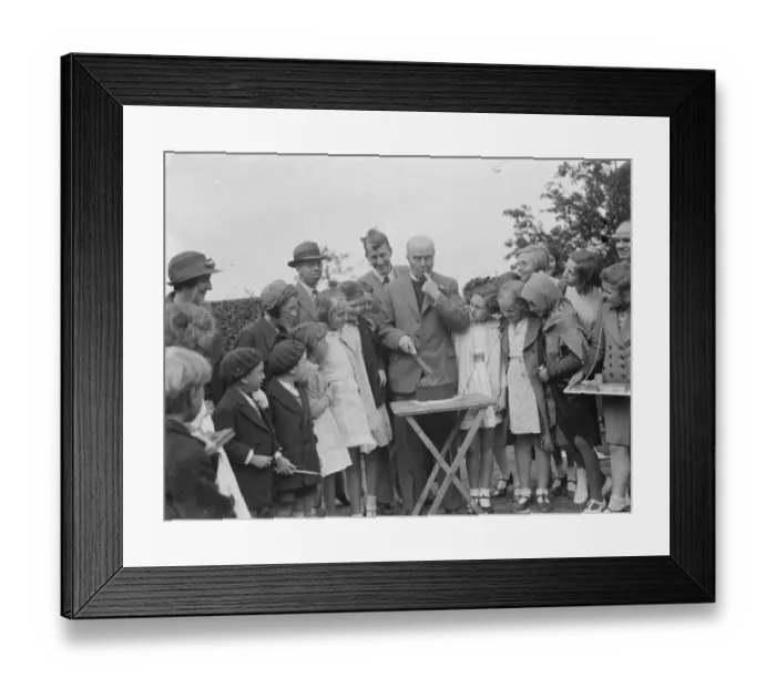 Framed Print : Canon Rs Greaves shows of a cake to children in Chislehurst, Kent Framed Print : Canon Rs Greaves shows of a cake to children in Chislehurst, Kent