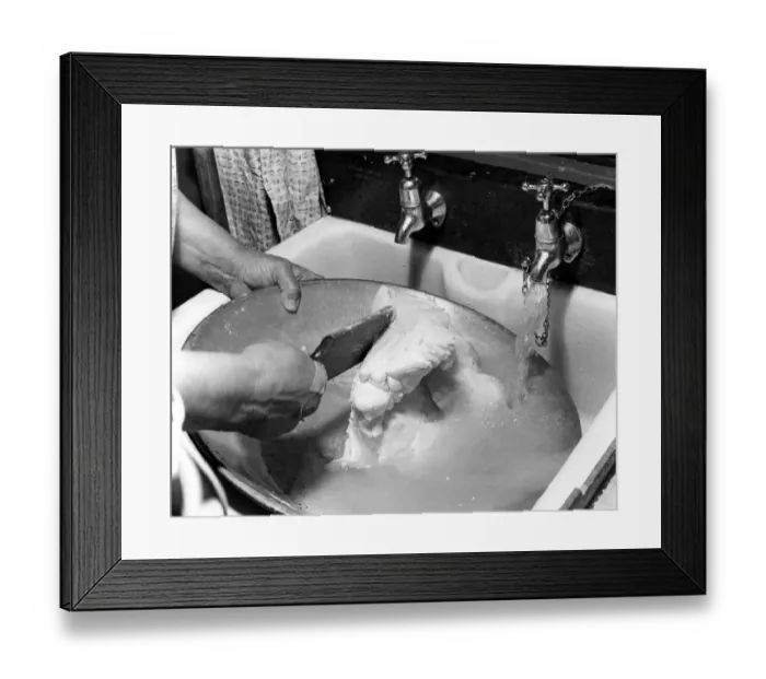 Framed Print : Miss Peggy Macleod washing out the bowl after making butter by hand in Daliburgh