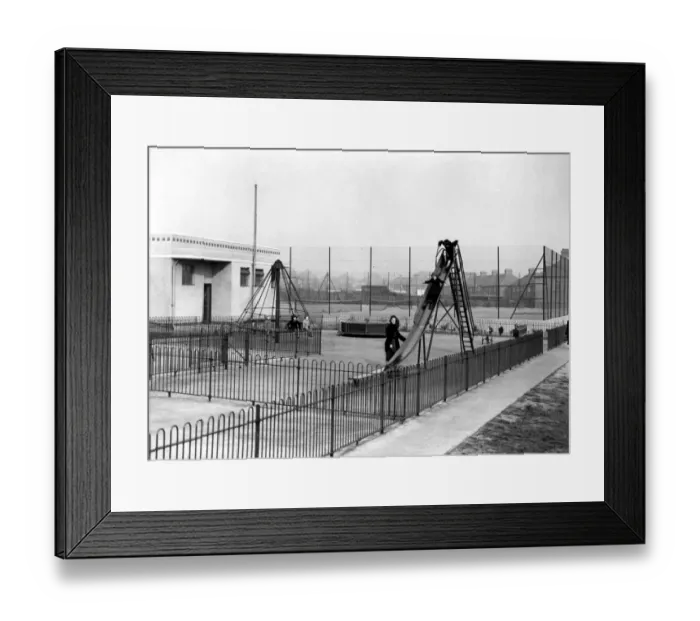 Framed Print : The childrens playground : a mother takes her children to play on the deserted slide