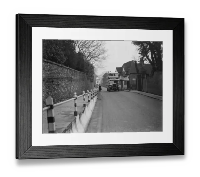 Framed Print : A double decker bus driving past some old cottages on a street in Ashford, Kent