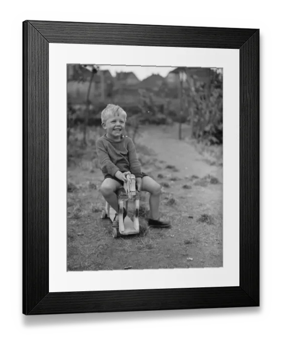 Framed Print : Brian Griffiths riding a wooden horse. 1938 Framed Print : Brian Griffiths riding a wooden horse. 1938
