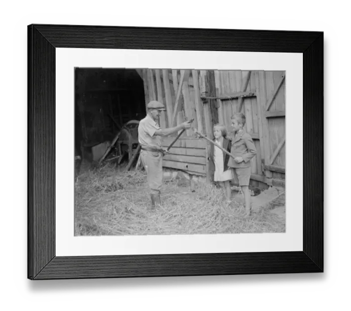 Framed Print : Jimmy Burrows showing flail to children. 1935 Framed Print : Jimmy Burrows showing flail to children. 1935