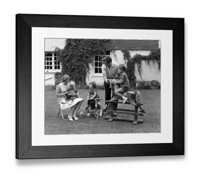 Framed Print : Family in the garden with mother with toddler on her lap, girl on a tricycle Framed Print : Family in the garden with mother with toddler on her lap, girl on a tricycle