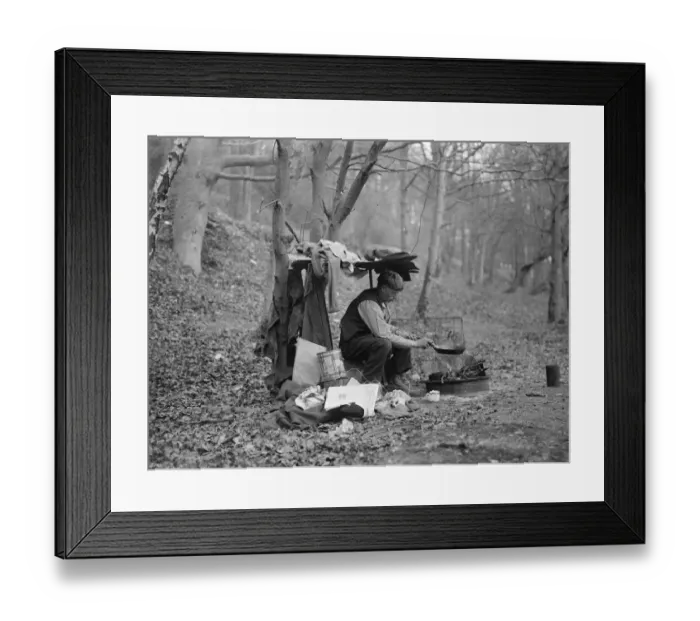 Framed Print : Tramp at home in woods cooking food over a camp fire. 1935