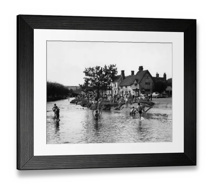 Framed Print : Families play in the flood water in Eynsford, Kent. Some of the children paddle others Framed Print : Families play in the flood water in Eynsford, Kent. Some of the children paddle others