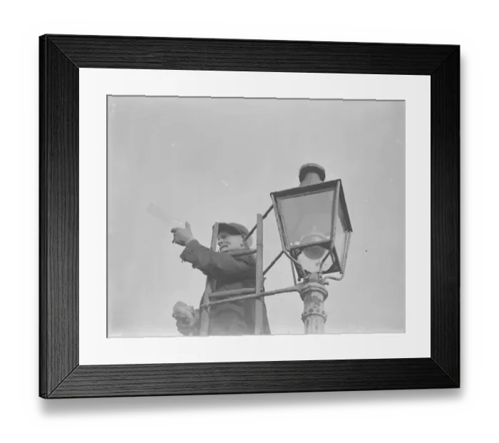 Framed Print : An elderly man lighting an oil street lamp in Hokenden, Kent. 1939