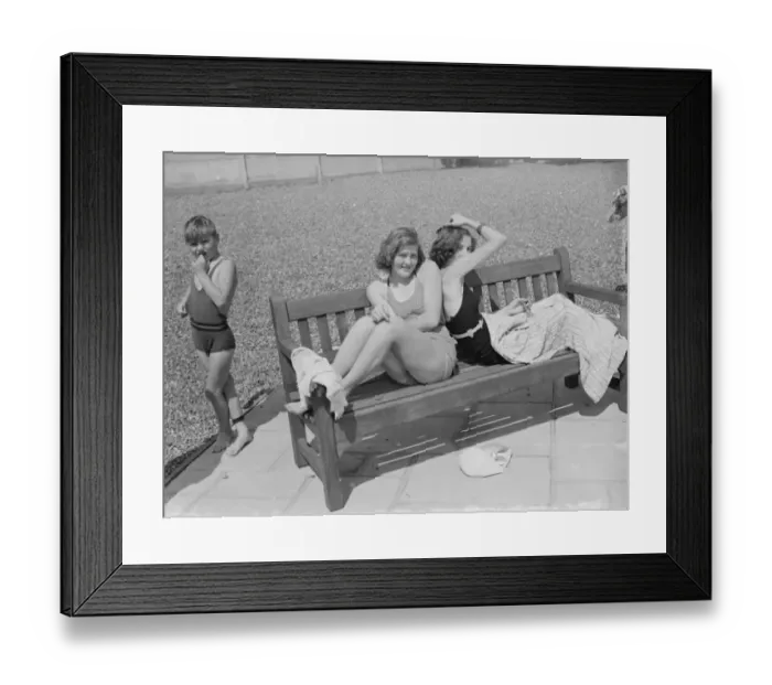 Framed Print : Two girls enjoy the sun in their swimming costumes by the side of a bathing pool Framed Print : Two girls enjoy the sun in their swimming costumes by the side of a bathing pool