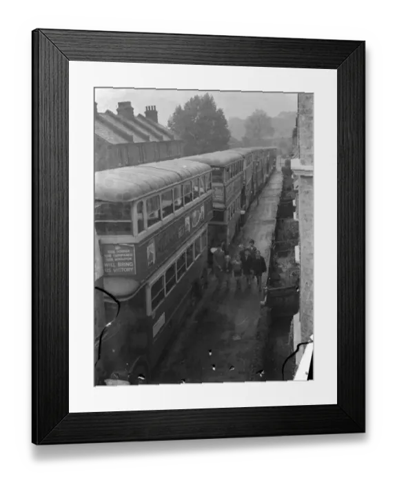 Framed Print : A group of children walking past a seriers of London Transport buses which are parked Framed Print : A group of children walking past a seriers of London Transport buses which are parked