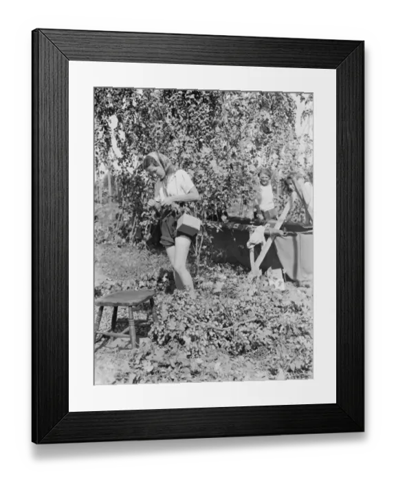 Framed Print : Women hop pickers in Beltring, Kent. Each worker has a gas mask over their shoulder