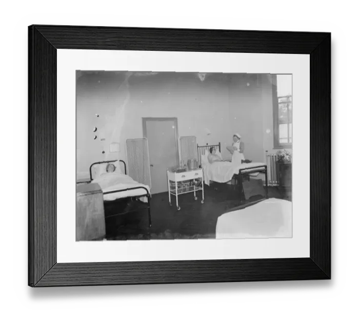 Framed Print : The Sidcup Cottage Hospital in Kent. A nurse tends to a patient in the womens ward Framed Print : The Sidcup Cottage Hospital in Kent. A nurse tends to a patient in the womens ward