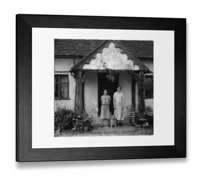Framed Print : Two sisters and a dog pose in front of a cottage. 1936 Framed Print : Two sisters and a dog pose in front of a cottage. 1936