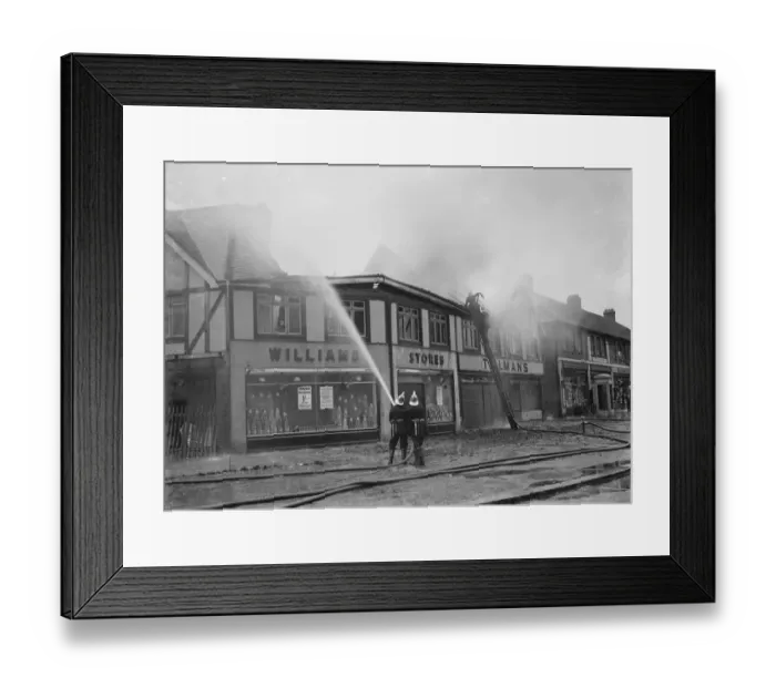 Framed Print : Firemen attempt to put out fires in a parade of shops in Welling, Kent Framed Print : Firemen attempt to put out fires in a parade of shops in Welling, Kent
