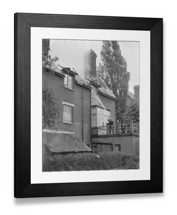 Framed Print : Firemen respond to a house fire in Chislehurst, Kent. A fireman hoses water into Framed Print : Firemen respond to a house fire in Chislehurst, Kent. A fireman hoses water into