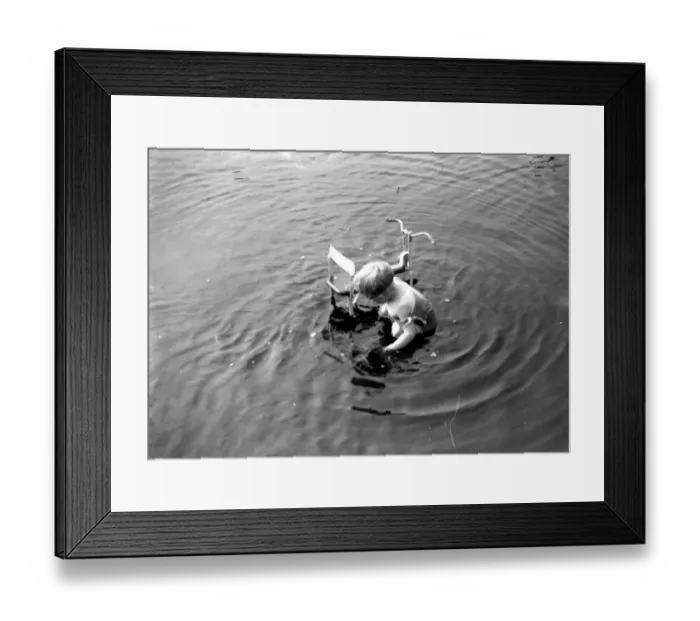 Framed Print : Little boy plays with a trike in the water. 1933 Framed Print : Little boy plays with a trike in the water. 1933