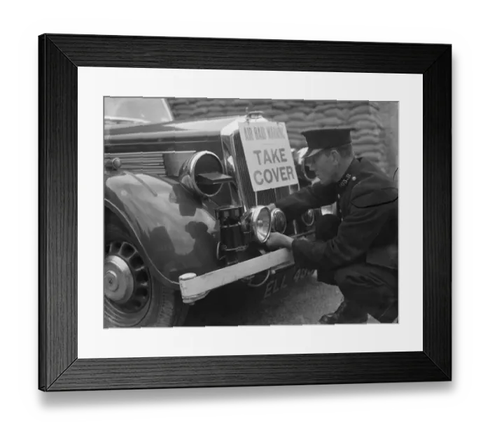 Framed Print : A policeman is fitting an air raid siren along with a warning sign to a police car Framed Print : A policeman is fitting an air raid siren along with a warning sign to a police car