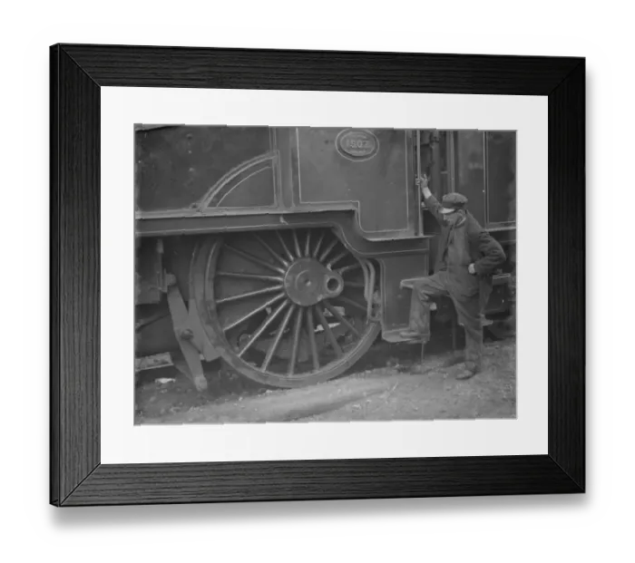 Framed Print : A train engineer looks at one of the large engine wheels after being derailed at Swanley Framed Print : A train engineer looks at one of the large engine wheels after being derailed at Swanley