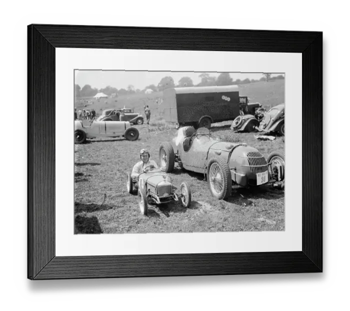 Framed Print : Peter McClure sits in a toy race car, parked next to the real thing, in Lullingstone Framed Print : Peter McClure sits in a toy race car, parked next to the real thing, in Lullingstone