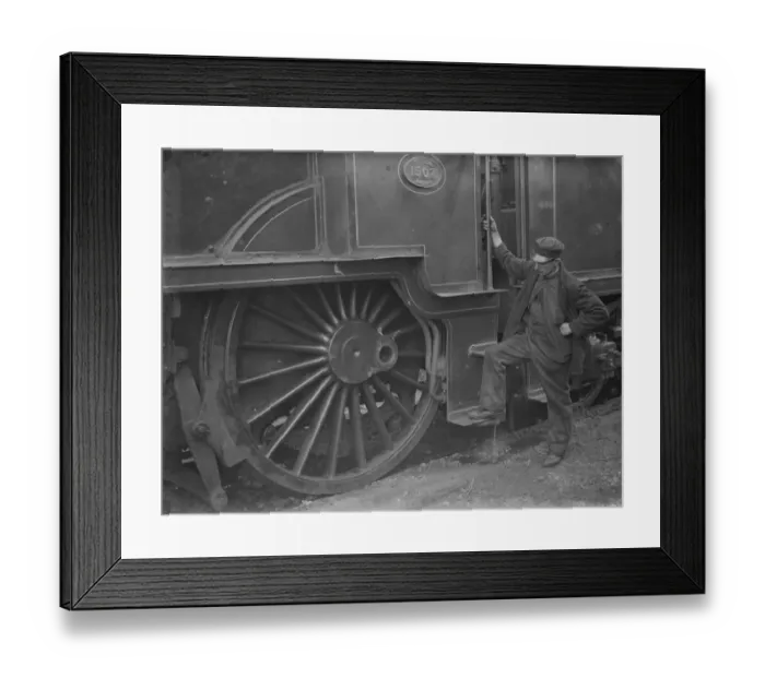 Framed Print : A train engineer looks at one of the large engine wheels after being derailed at Swanley Framed Print : A train engineer looks at one of the large engine wheels after being derailed at Swanley