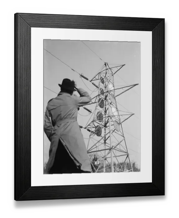 Framed Print : A man stands looking up at an electricity pylon in Shoreham, Kent. 1936