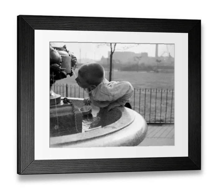 Framed Print : London summer. A little boy drinks water from a fountain. 1933