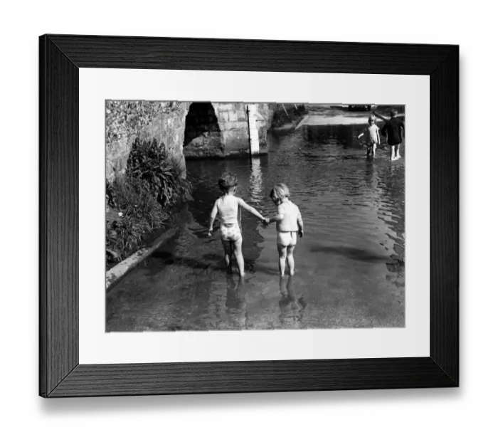 Framed Print : Two small children hold hands as they tentatively paddle deeper. Eynsford, Kent Framed Print : Two small children hold hands as they tentatively paddle deeper. Eynsford, Kent