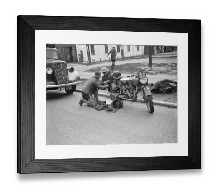 Framed Print : An army motorcyclist performs some maintenance on his Royal Enfield 25 CC motorcycles Framed Print : An army motorcyclist performs some maintenance on his Royal Enfield 25 CC motorcycles