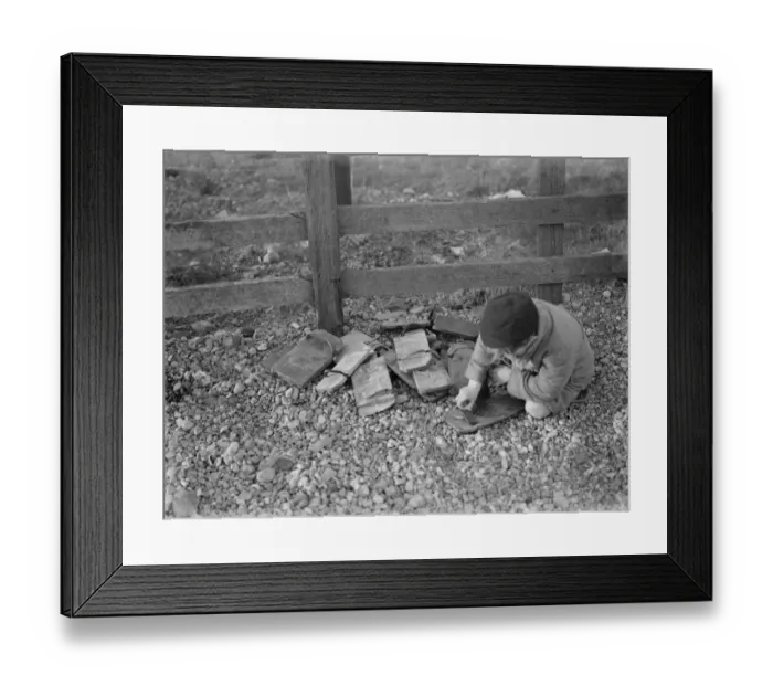 Framed Print : Children playing on the shingle beach at Dungeness. A child trys on a special