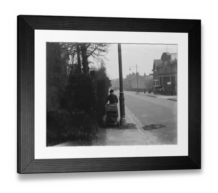 Framed Print : A woman pushes a pram past a street light which is shrouded by branches in Sidcup, Kent Framed Print : A woman pushes a pram past a street light which is shrouded by branches in Sidcup, Kent