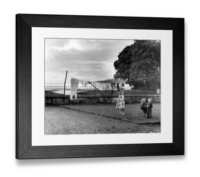Framed Print : Washing day at one of the cottages, a mother pegging out the clothes, Island of Framed Print : Washing day at one of the cottages, a mother pegging out the clothes, Island of