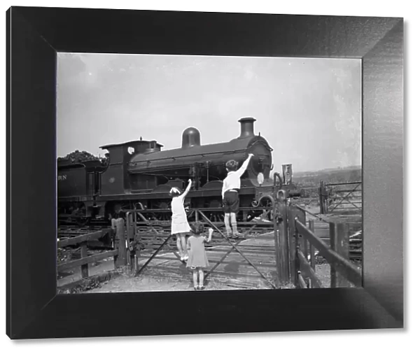 children waving to the train driver. 1936