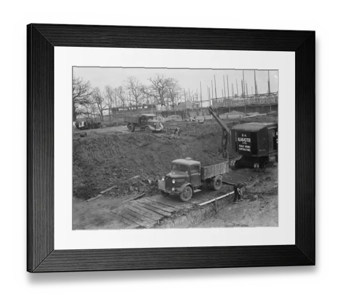 Framed Print : Digger clears the land and puts soil into the back of Bedford truck on the site of Framed Print : Digger clears the land and puts soil into the back of Bedford truck on the site of