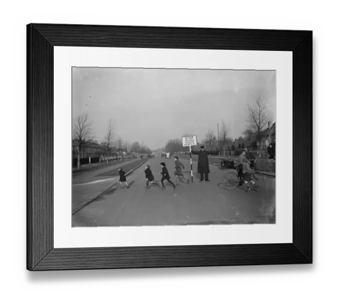 Framed Print : Road attendant from Kent County Council, holding a sign, helps children in St Mary Framed Print : Road attendant from Kent County Council, holding a sign, helps children in St Mary