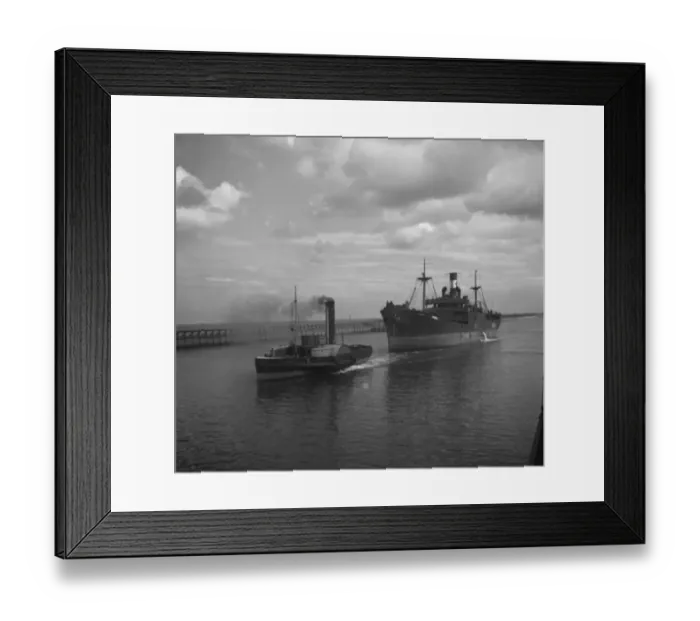 Framed Print : Merchant ship under tow from a paddle steamer tug. 1936 Framed Print : Merchant ship under tow from a paddle steamer tug. 1936