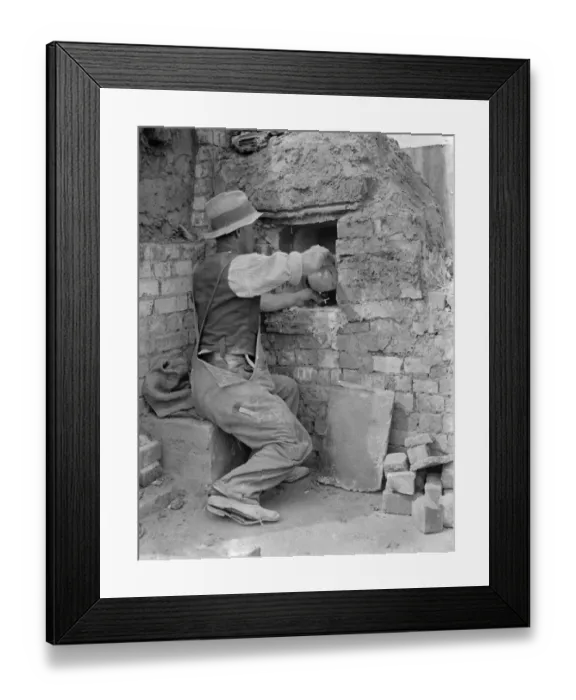 Framed Print : Pottery maker Mr Sadler filling clay into a kiln. 1938