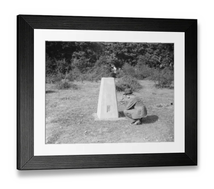 Framed Print : A man crouching at a boundary post in Kemsing, Kent. 1938 Framed Print : A man crouching at a boundary post in Kemsing, Kent. 1938