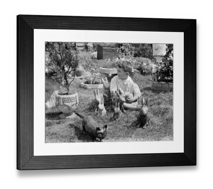 Framed Print : A little boy with some of the clay rabbits made by Mr Sadler. 1938