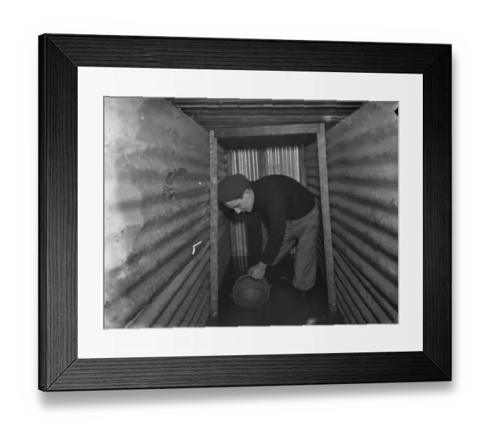 Framed Print : The interior of a flooded dug out in Sidcup, Kent. Mr George Harris attempts Framed Print : The interior of a flooded dug out in Sidcup, Kent. Mr George Harris attempts