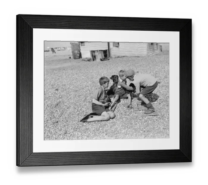 Framed Print : Boys playing on the shingle beach at Dungeness, Kent, wearing special wooden shoes Framed Print : Boys playing on the shingle beach at Dungeness, Kent, wearing special wooden shoes