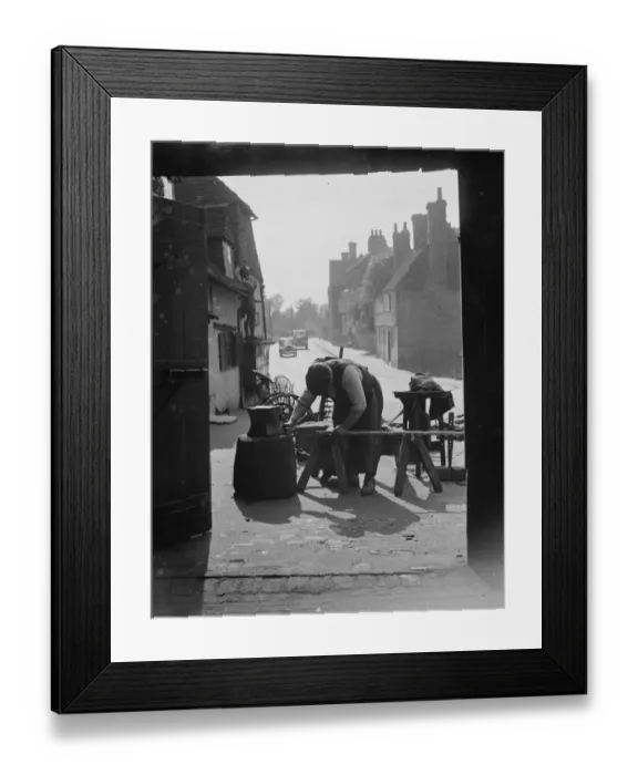 Framed Print : The Blacksmith at work at Westerham Forge, Kent. 1935 Framed Print : The Blacksmith at work at Westerham Forge, Kent. 1935