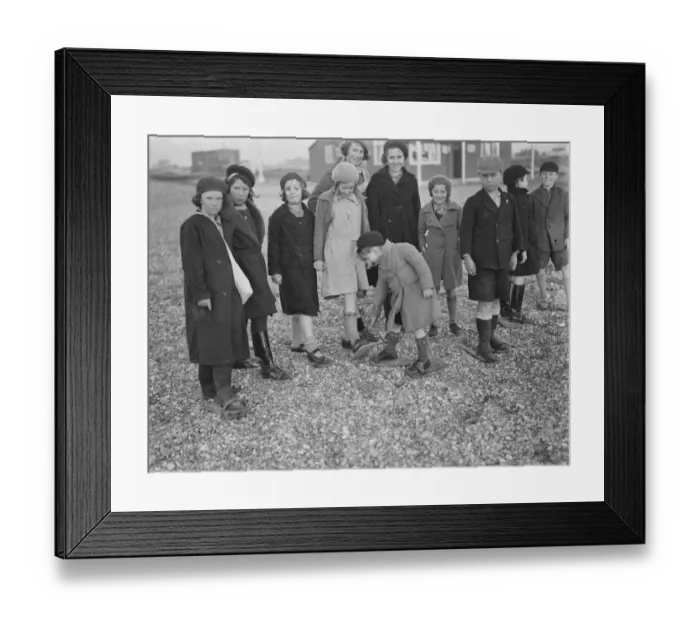 Framed Print : Children playing on the shingle beach at Dungeness. They use beach shoes to walk Framed Print : Children playing on the shingle beach at Dungeness. They use beach shoes to walk